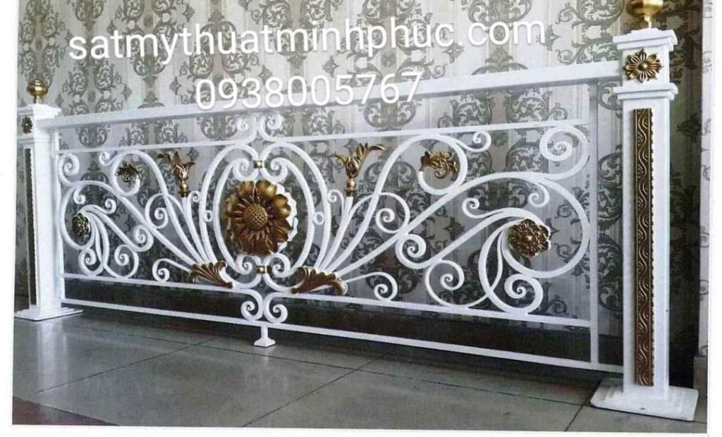 Lan can sắt mỹ thuật sơn trắng pha chi tiết mạ vàng, hoa văn cánh hoa đặt chính giữa, dùng trang trí khu vực nội thất.